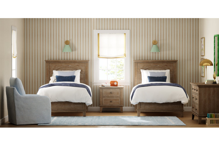 kids bedroom with two twin sized wooden beds and striped wallpaper with a matching end table in between