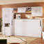 Lit simple blanc avec tablettes ouvertes et tiroirs, garde-robe et table encastrés