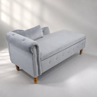 Chaise longue en velours gris avec rangement, oreiller et garniture cloutée pour les espaces de vie modernes