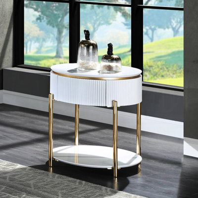 Table d'appoint blanche laquée brillante avec accents dorés et pieds en métal, de forme ovale et ronde, dotée d'un tiroir et d'une étagère de rangement, d'une hauteur de 61 cm et d'une profondeur de 56 cm, en bois composite et métal, idéale pour les espaces de vie.