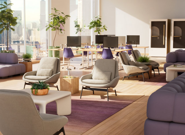 Bright, modern office lounge area featuring soft purple lounge seating, comfortable gray accent chairs, wood-topped side tables, and a dedicated workspace with desks and computers in the background.