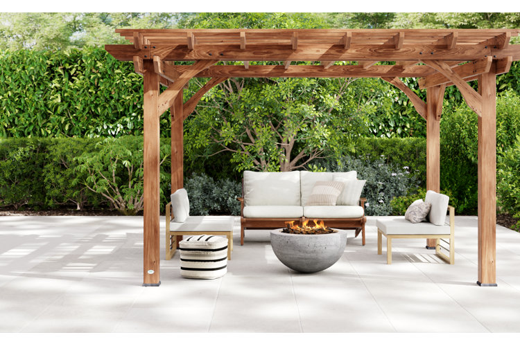 patio conversation set with white cushions and a round fire pit under a wooden pergola