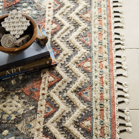 Patterned rug with tassels.