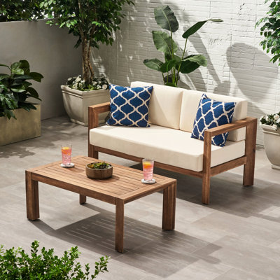 Meubles en bois : Table basse avec coussins moelleux résistants aux intempéries, beige et marron.