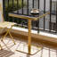 Table de bistrot carrée moderne de 61 cm (24 po) en faux marbre noir, idéale pour les petits espaces. Plateau avec revêtement UV, bordure en acier inoxydable doré et pied central. Facile à nettoyer.