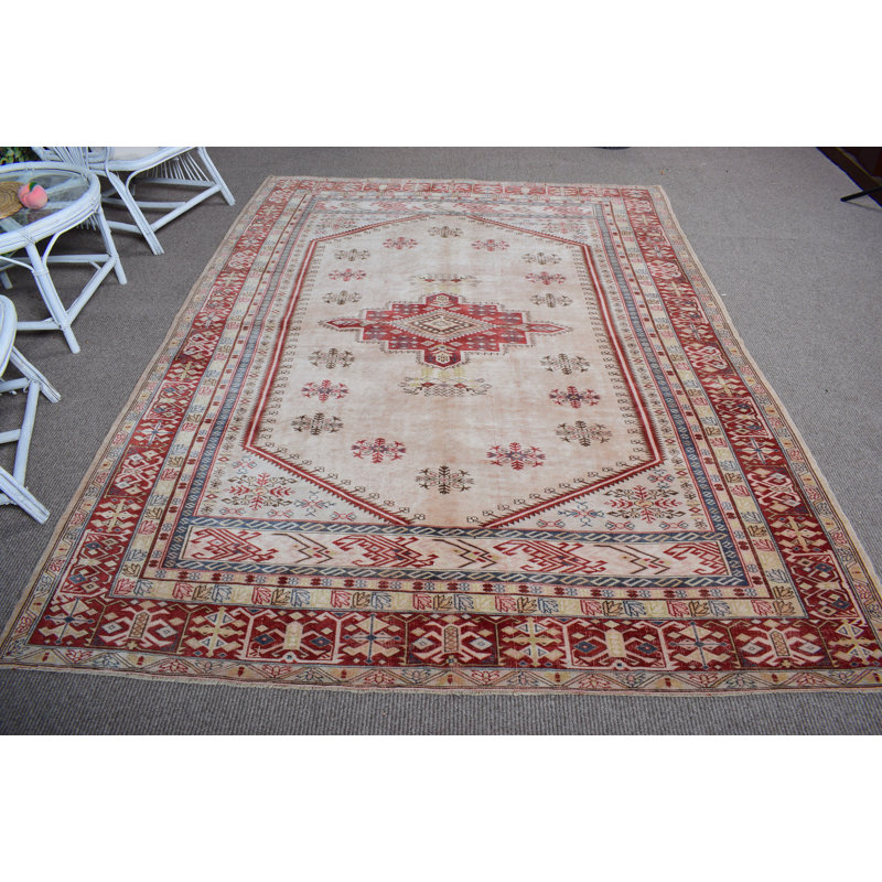 Tapis turc en laine avec des motifs géométriques dans des tons de rouge chaud et de beige pour un décor de salon élégant