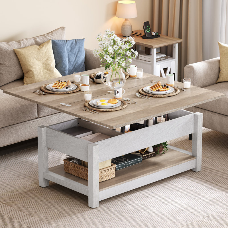 A modern coffee table in a minimalist living room, set for breakfast with plates of waffles, a vase with flowers, and soft pillows on the sofa.