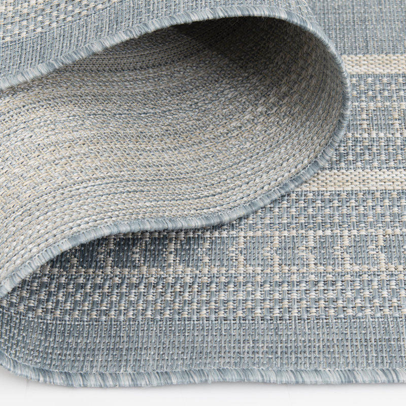 Tapis intérieur / extérieur en polypropylène à bordure bleu clair Bay Isle Home ™ Ceridwyn Sutton