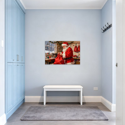 Père Noël de Noël cousant un sac rouge dans un atelier
