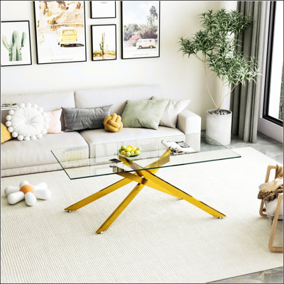 Élégante table basse rectangulaire en verre trempé transparent avec pieds en métal doré, parfaite pour les salons modernes