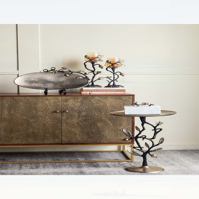 Élégante table d'appoint en aluminium noir et or avec un motif de grenade complexe, parfaite pour un décor moderne et artistique.