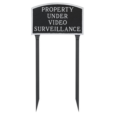 Grande arche sous un panneau de vidéosurveillance avec piquets