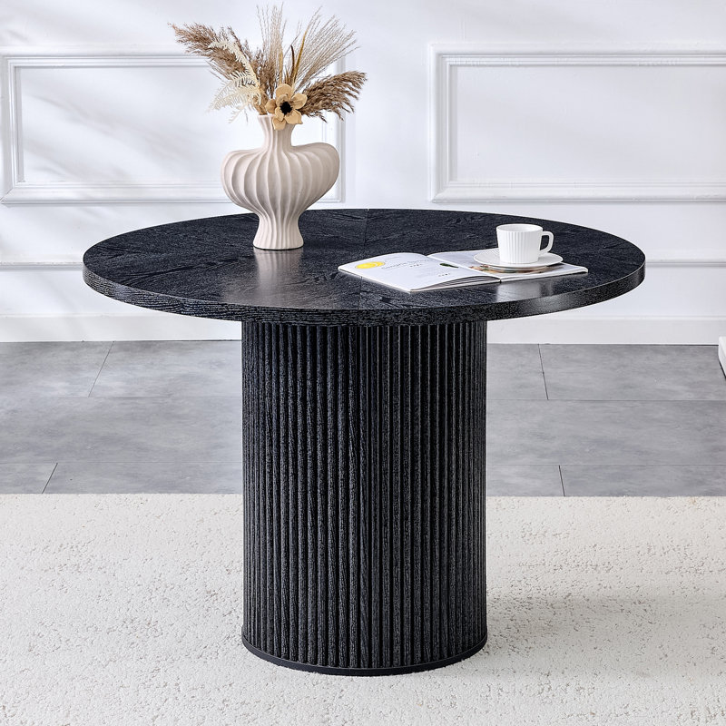 Une table de salle à manger circulaire épissée moderne d'un diamètre de 42 pouces, présentant des textures de couleur de bois noir en forme d'éventail en diagonale, interprétant l'esthétique et la fonctionnalité de la maison.