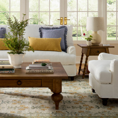 Living room interior with white sofa and yellow and blue pillows.