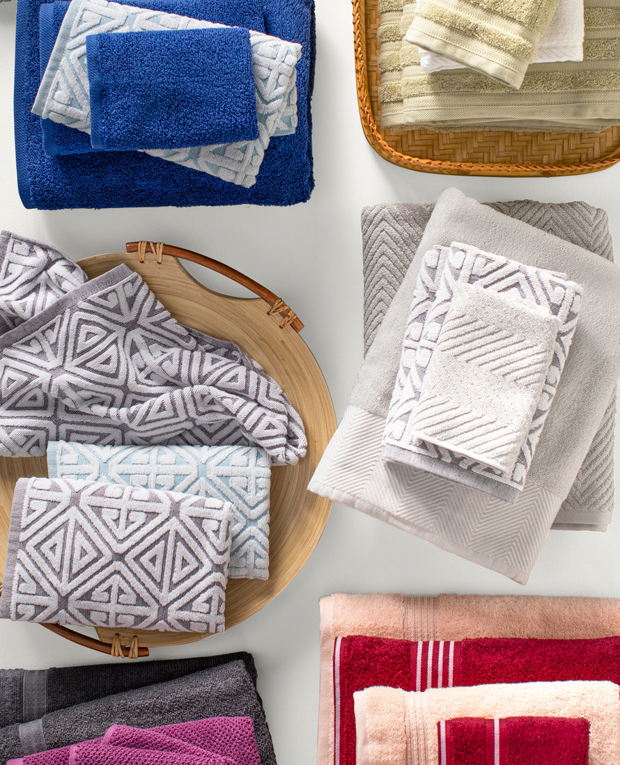 Overhead view of various folded and stacked bath towels in different textures and colors.