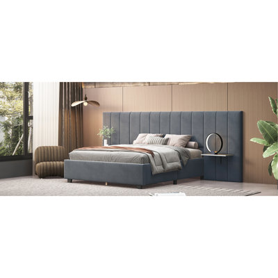 Grand lit plateforme tapissier gris avec tête de lit élégante et tablettes spacieuses et pratiques