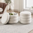 Pouf de rangement rond moderne Widman de 49,5 cm de large, recouvert de tissu, avec compartiment de rangement dissimulé