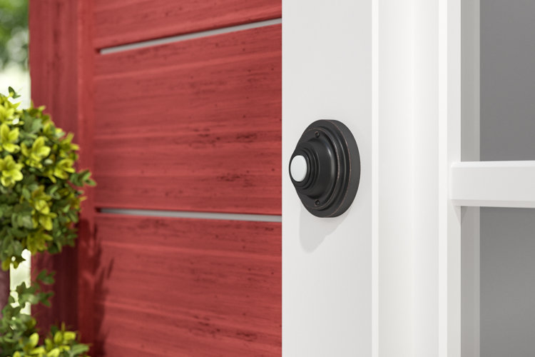 round oil-rubbed bronze doorbell on a white door