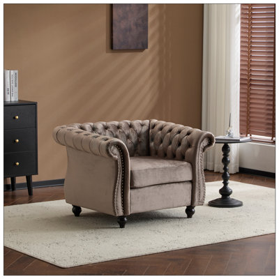 Fauteuil club Chesterfield avec capitonnage à boutons profonds, accoudoirs roulés et garnitures cloutées pour une élégance et un confort classiques