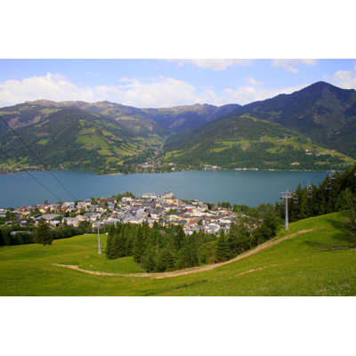 Pré vert au-dessus de Zell am See et lac bleu, en Autriche, par Agustavop