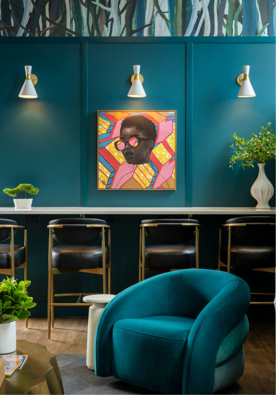 Interior view of a room with blue walls, a colorful painting, and teal furniture.