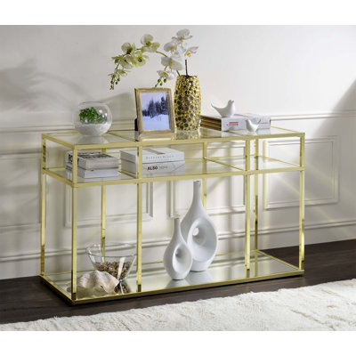 Table de canapé Uchenna en verre transparent et finition dorée avec plateau en verre trempé et structure en métal, parfait pour les décors modernes