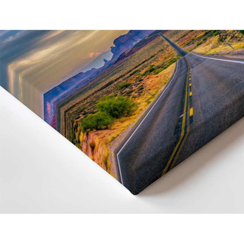 Toile «A Long Winding Asphalt Road Stretches Through A Vast Desert», art mural, paysage encadré de roches rouges