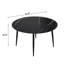 Table de salle à manger ronde avec base noire en métal et égratignure