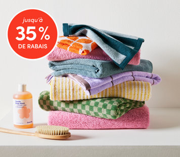Essentiels de salle de bain jusqu'à 35 % de rabais avec serviettes colorées empilées, gel douche et brosse