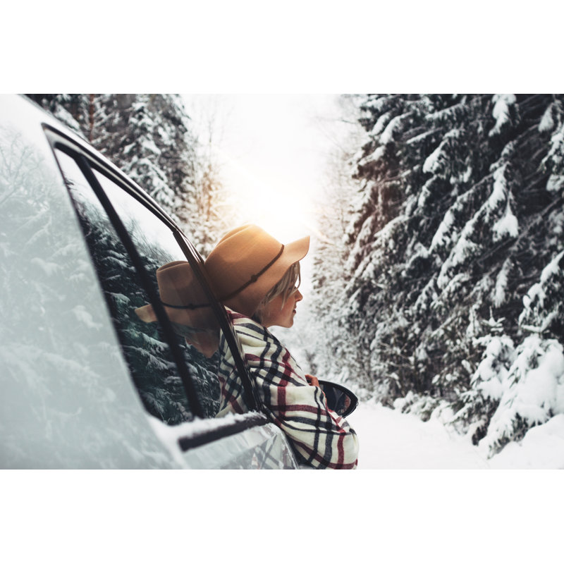Beautiful Woman Traveler Wearing Hat And Scarf Leant Out Of The Car Window And Enjoying Of Winter Road And Forest. Young Hipster Traveling By Car In Winter Holidays by Leonidkos - Wrapped Canvas Print