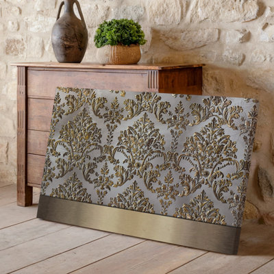La toile crée un design de papier peint élégant avec un motif damassé complexe en or chatoyant contre un taupe doux