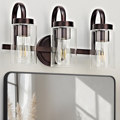 Applique murale moderne de 40,6 cm (16 po) à 3 lumières, fini bronze huilé, avec abat-jour en verre transparent, à fixer au-dessus d'un miroir.