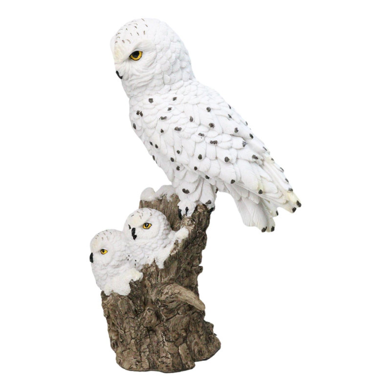 Figurine familiale représentant une chouette harfang des neiges et ses deux petits sur une souche d'arbre enneigée