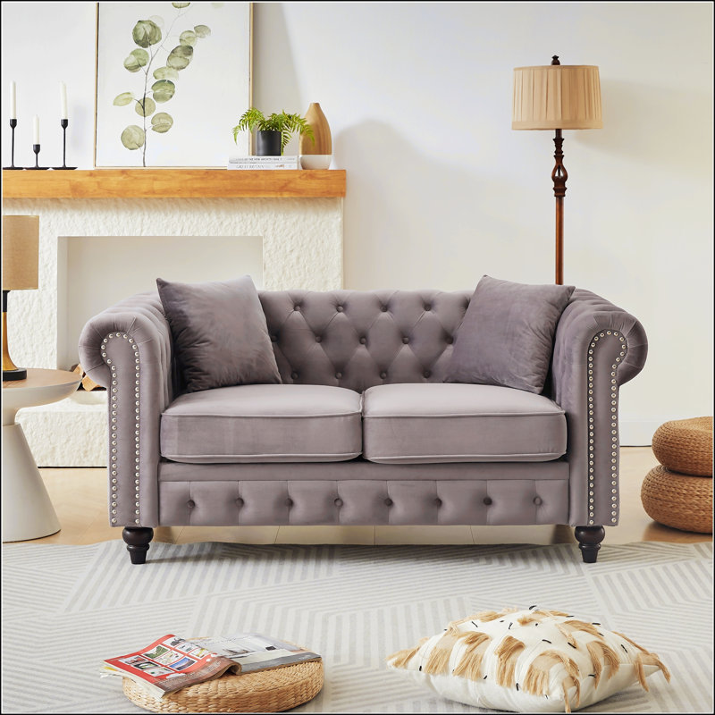 Luxueux canapé Chesterfield en velours avec capitonnage à boutons et garniture cloutée, parfait pour les salons modernes et élégants.