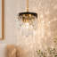 Suspension Grigor à une lumière en cristal, style moderne noir et laiton, à intensité variable, idéale pour îlot de cuisine.
