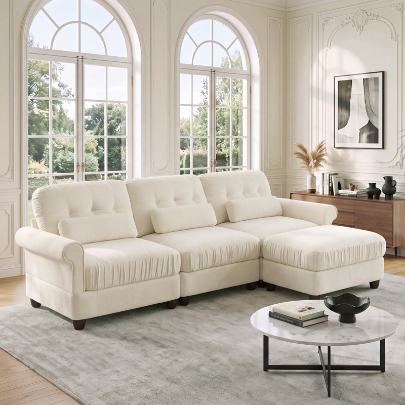 Canapé d'angle modulaire 3 places en chenille avec pouf, assise profonde avec dossier capitonné, coussins à bords froncés, accoudoirs arrondis et coussins lombaires pour salon