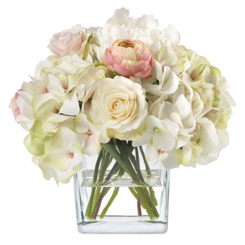 Bouquet d'hortensias roses et blancs dans un vase cubique en verre