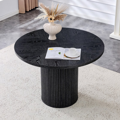 Une table de salle à manger circulaire épissée moderne d'un diamètre de 42 pouces, présentant des textures de couleur de bois noir en forme d'éventail en diagonale, interprétant l'esthétique et la fonctionnalité de la maison.