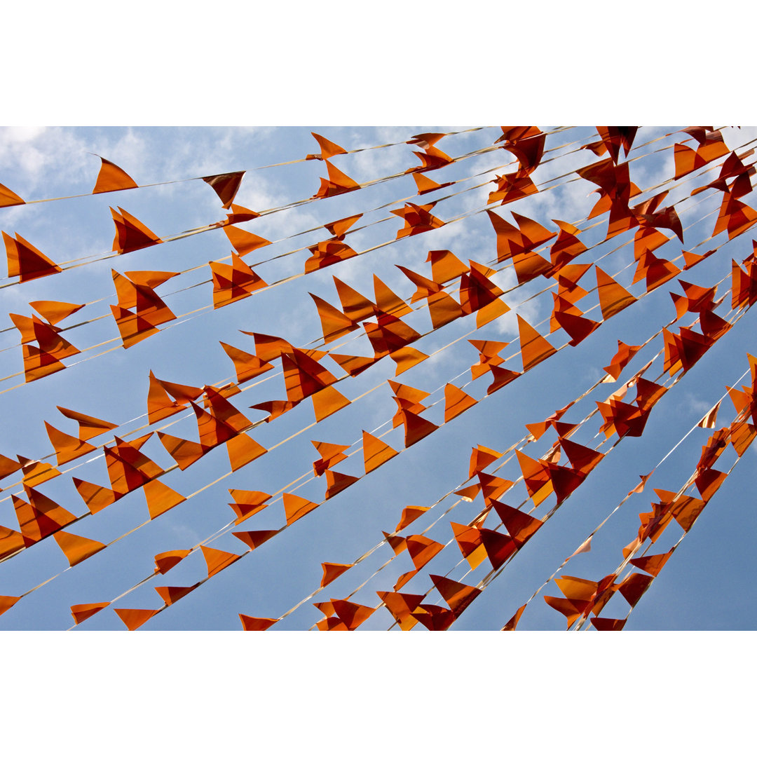 Leinwandbild Orange Flags Against a Blue Sky