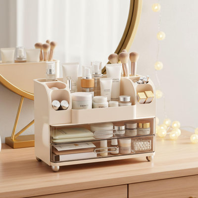 Boîte de rangement pour cosmétiques à double tiroir de couleur crème. Convient aux coiffeuses, aux comptoirs de salle de bain et aux bureaux. Organise les produits de beauté soigneusement et garde les surfaces bien rangées. Une solution élégante et pratique.