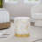 Stylish Leather Ottoman With Gold Metal Base And Splatter Accents For Glam Interior Design