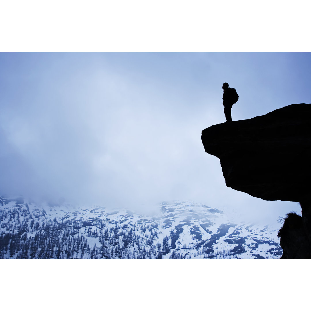 Silhouette Of Man On A Hill Overlooking Snowy Mountains von Lopurice - No Frame Set auf Leinwand