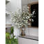 Grandes branches de cerisier en fleurs dans un vase en verre