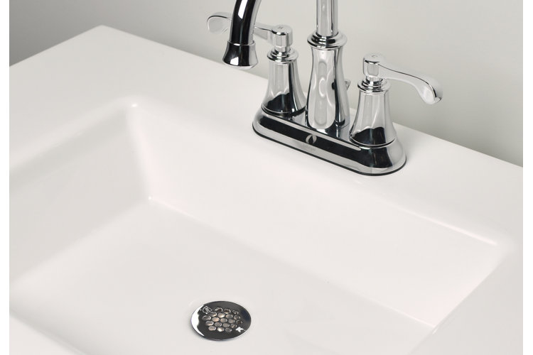 chrome finish grid drain in a white bathroom sink