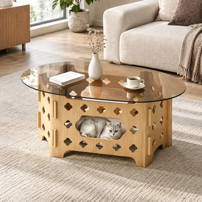 Table basse ovale avec dessus en verre trempé caramel et piètement en bois sculpté pour petits espaces
