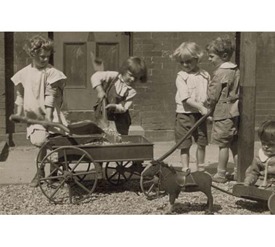 Les enfants chargent des pierres dans un chariot avec une pelle - reproduction de photo