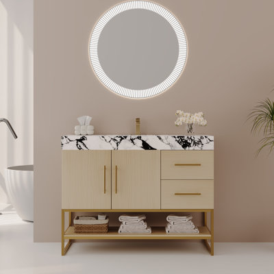 Meuble-lavabo autoportant moderne de 91 cm (36 po) avec comptoir en pierre frittée, lavabo en céramique intégré, armoire en chêne clair, structure en acier inoxydable doré, tiroirs fermés et tablette de rangement ouverte pour salle de bain résidentielle.