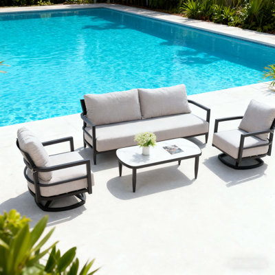Ensemble de conversation extérieur 4 pièces avec fauteuils club modernes, canapé luxueux avec banc, table basse en pierre frittée d'inspiration marbre, structure en aluminium antirouille Ember et coussins en fonte Sunbrella