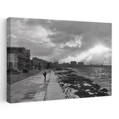 Années 1930, années 1940, homme silhouette anonyme marchant le long du mur de la mer de La Havane au coucher du soleil