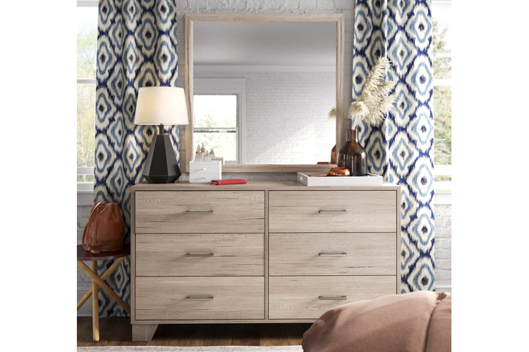 light wood chest with decor and above mirror